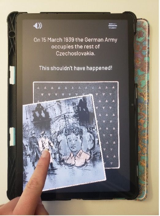 A hand interacts with a tablet displaying an educational app. The screen reads: “On 15 March 1939 the German Army occupies the rest of Czechoslovakia. This shouldn't have happened!” Below the text is a grayscale illustration showing German soldiers and distressed civilians. A finger points to a highlighted figure, indicating active engagement with the content.
